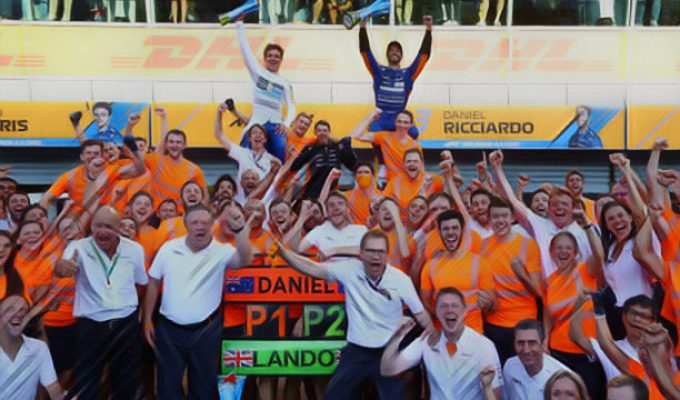 Daniel Ricciardo celebrates with teammate Lando Norris and the whole McLaren crew